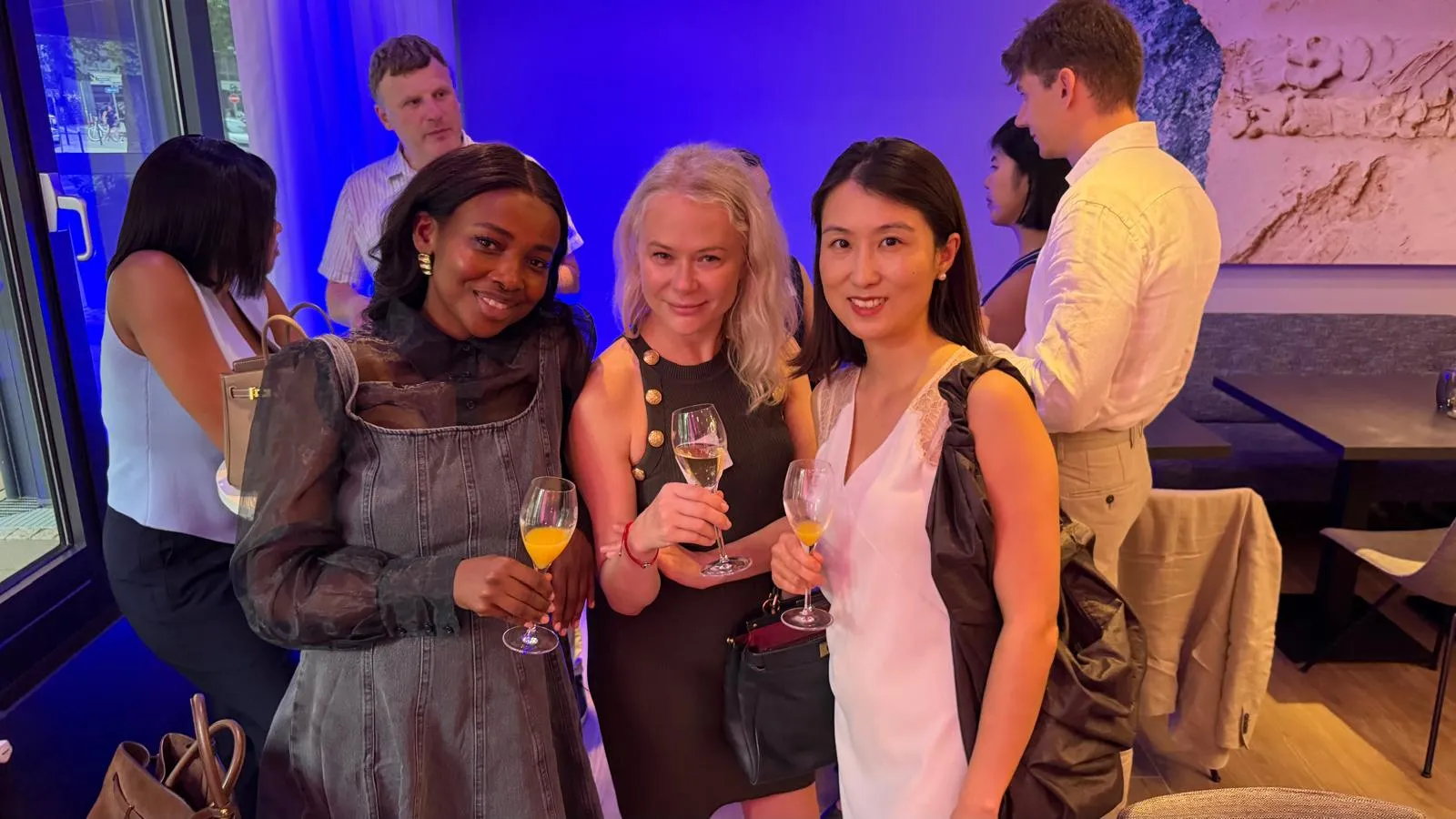 Three guests with a glass of sparkling wine during the networking part