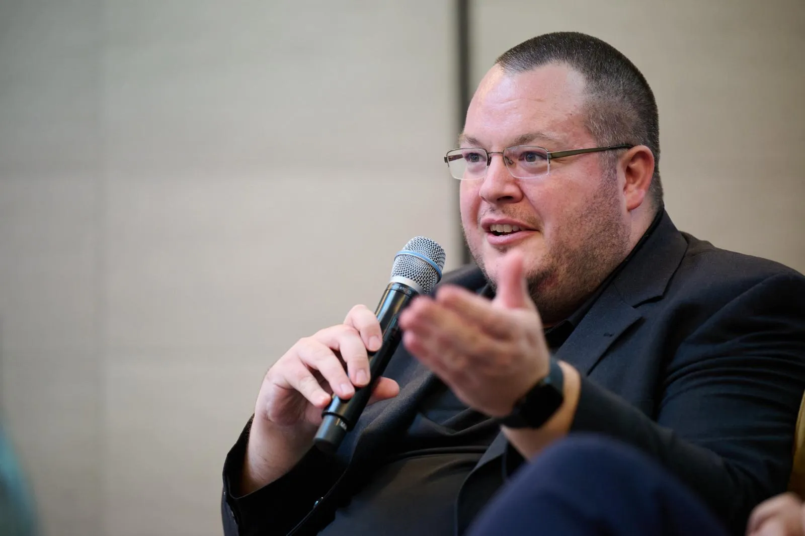 Ein Mitglied des Panels gestikuliert beim Sprechen auf der Bühne